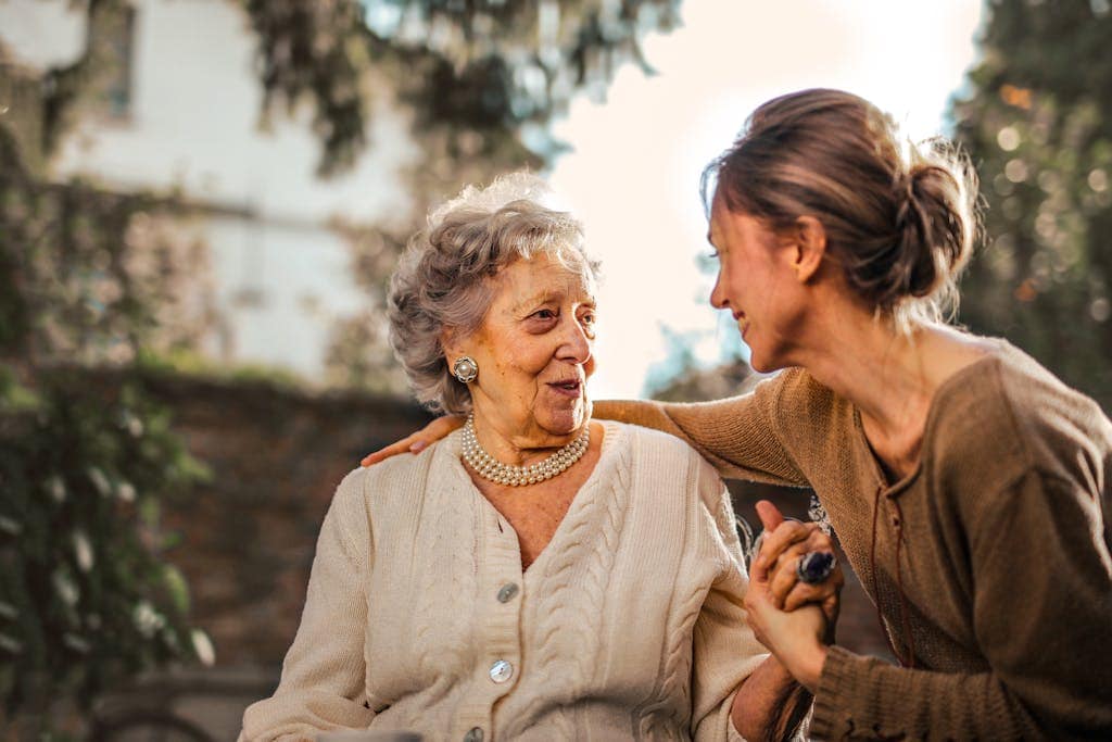 When is mothers day in New Zealand? Joyful adult daughter greeting happy surprised senior mother in garden